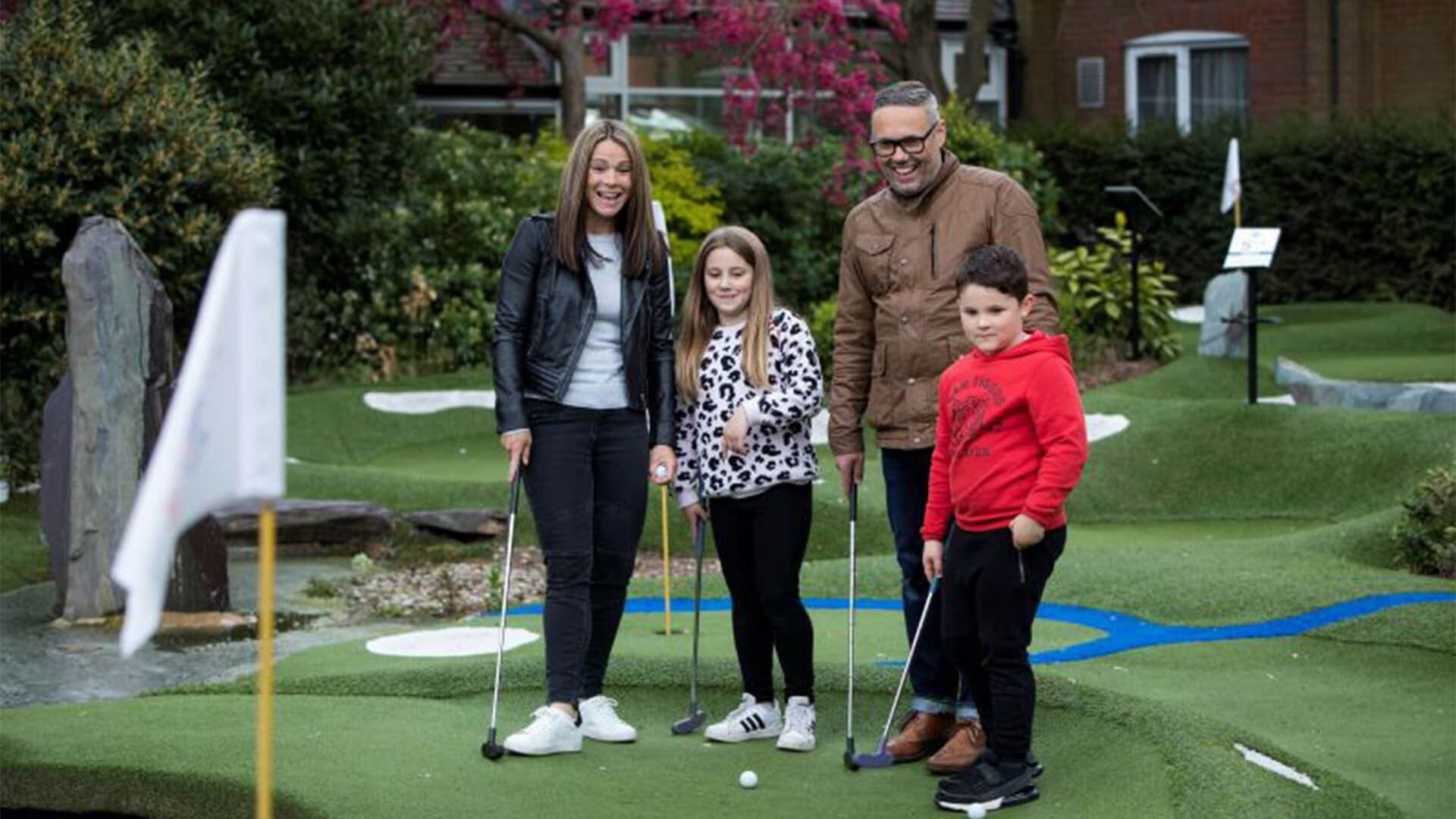 family playing mini golf