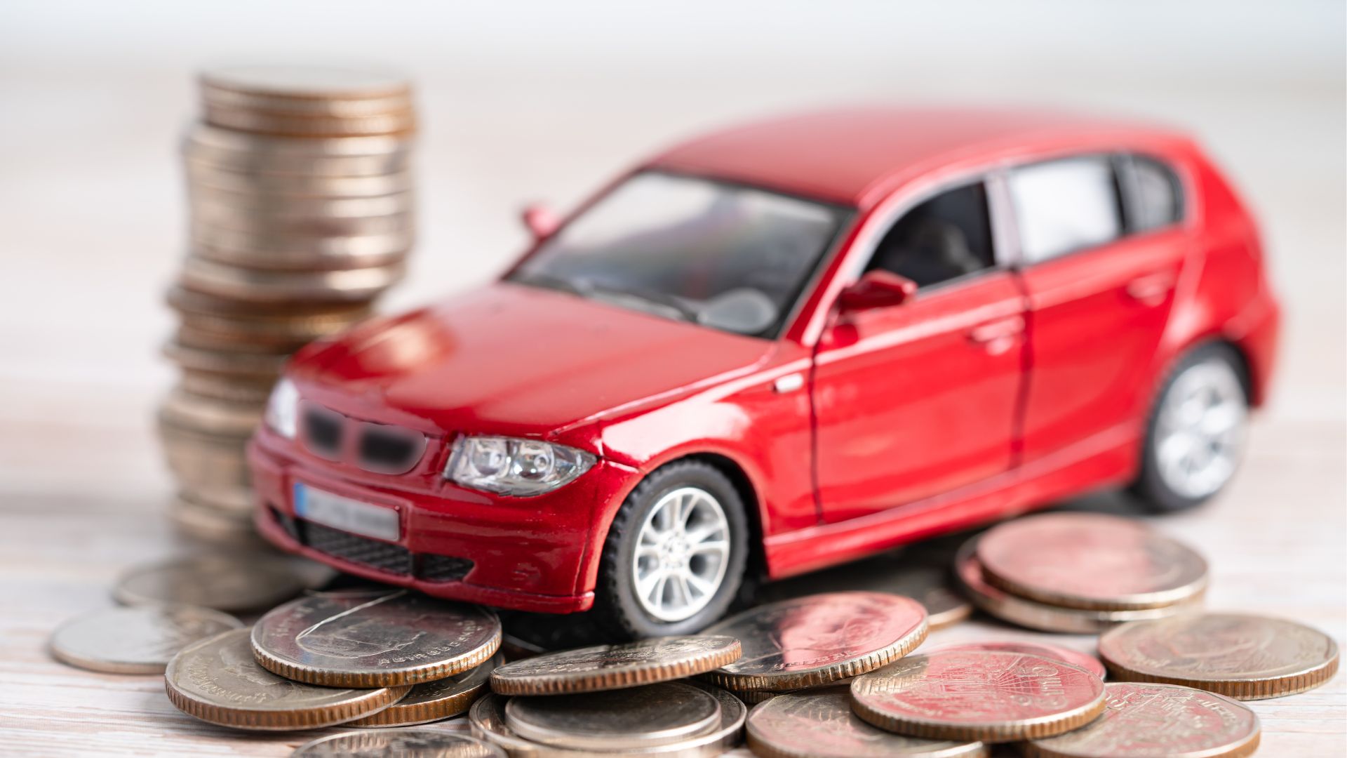 A toy car atop a pile of loose coins